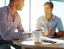 Businessmen sitting in a meeting with coffee